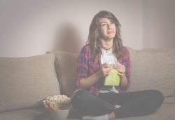 a woman crying, sitting on the sofa holding a box of tissues