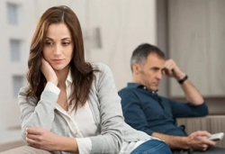 A couple, man looking fed up and a women looking away also not happy