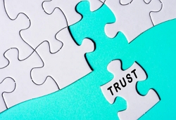 Jigsaw puzzle with last piece reading trust. Let go of control and feel safe in life