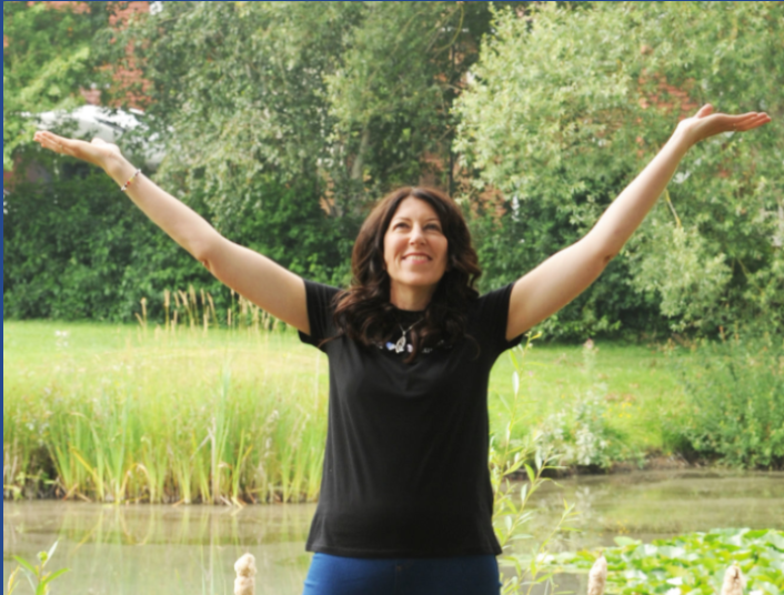 me, Rebecca Bishop, being my authentic self, hands outstretched, smiling, trees in the background